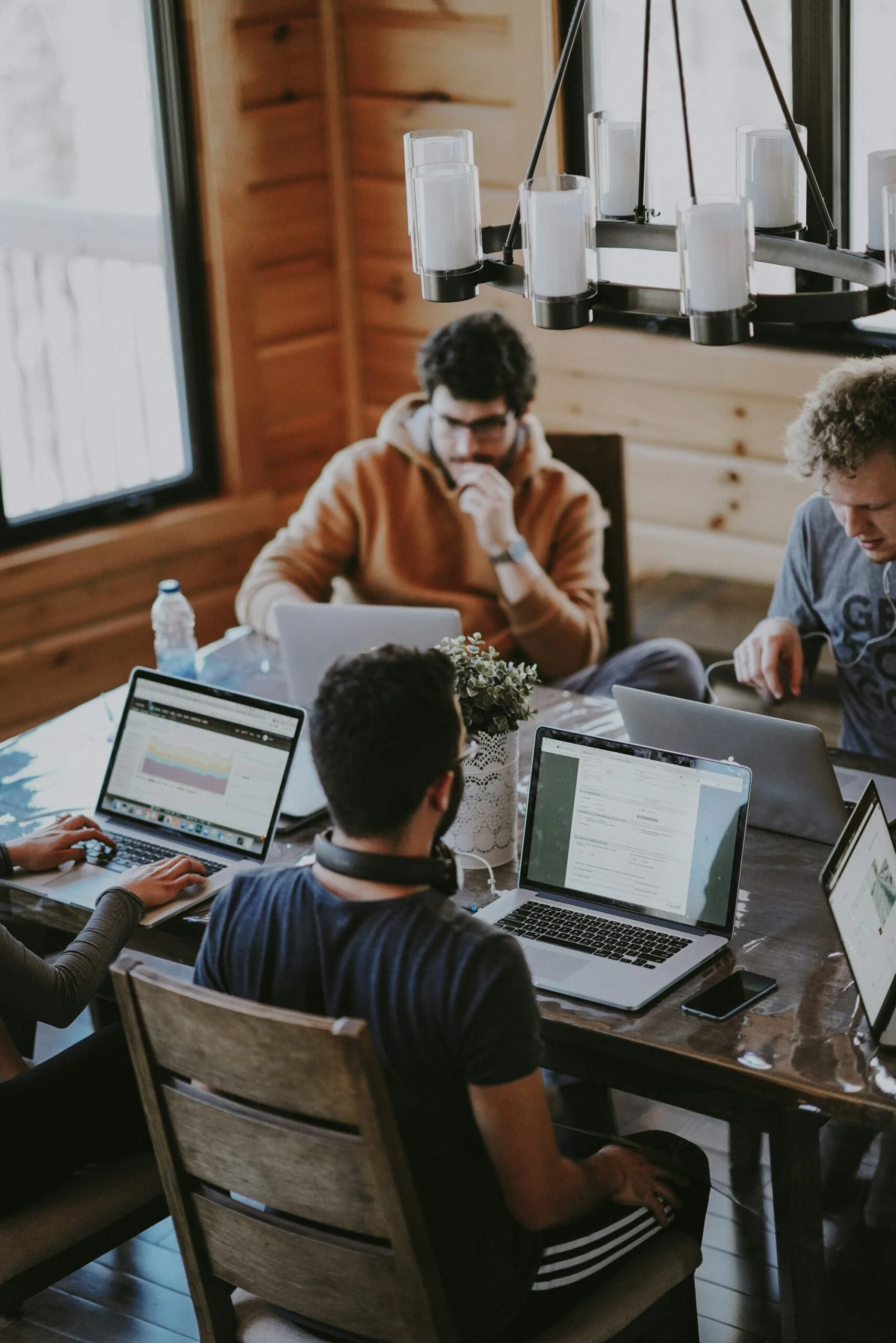 Operations team reviewing metrics together at a long desk in a glass-walled meeting room